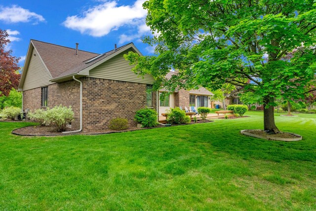 836 Boutell Dr, Grand Blanc, MI 48439 - view of side of property with brick siding, a yard, and a shingled roof