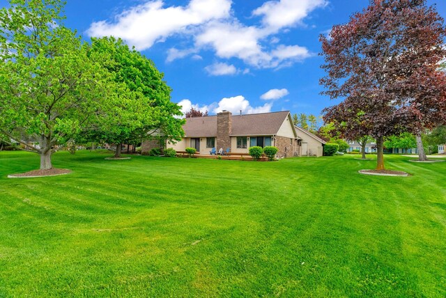 836 Boutell Dr, Grand Blanc, MI 48439 - ranch-style home with a front lawn, a chimney, and brick siding
