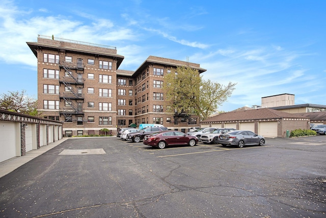 view of apartment building / complex featuring community garages and uncovered parking