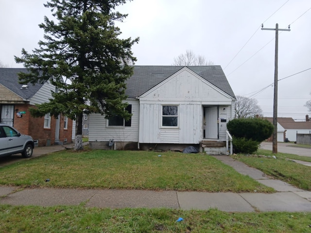 20000 Pelkey St, Detroit, MI 48205 - view of front of house with board and batten siding, a front yard, and roof with shingles