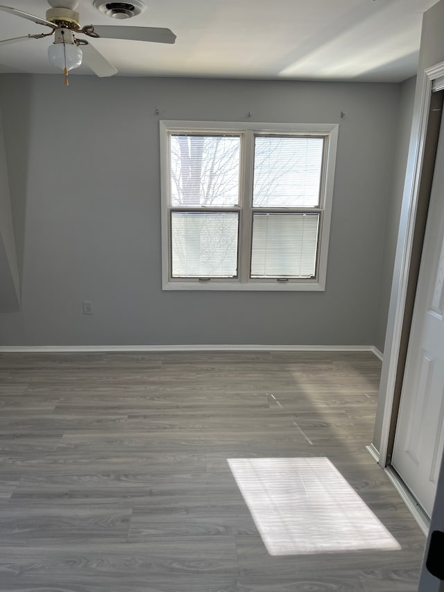 spare room with a ceiling fan, baseboards, and wood finished floors