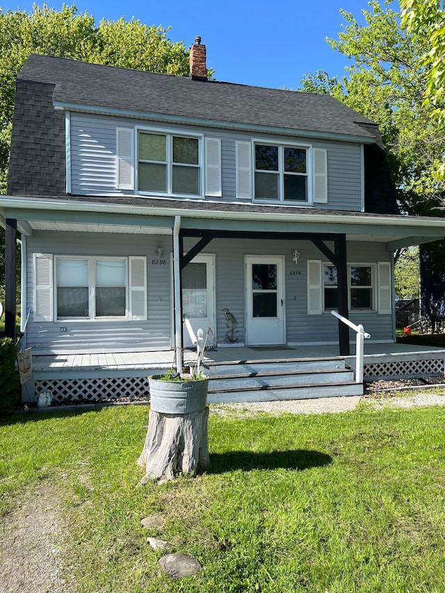 view of front of house featuring a chimney, a porch, a front lawn, and roof with shingles