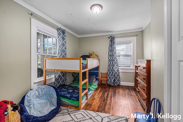 bedroom with hardwood / wood-style flooring, multiple windows, ornamental molding, and baseboards