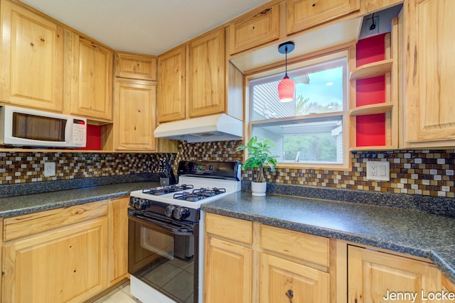 608 Porter Rd, Norton Shores, MI 49441 - kitchen featuring gas stove, white microwave, under cabinet range hood, and dark countertops