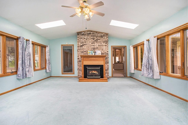 unfurnished living room featuring a skylight, a fireplace, baseboards, vaulted ceiling, and carpet floors