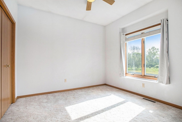 unfurnished bedroom with light carpet, baseboards, a closet, and a ceiling fan