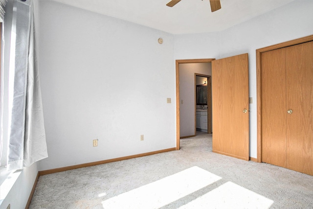 unfurnished bedroom featuring carpet floors, a closet, baseboards, and ceiling fan