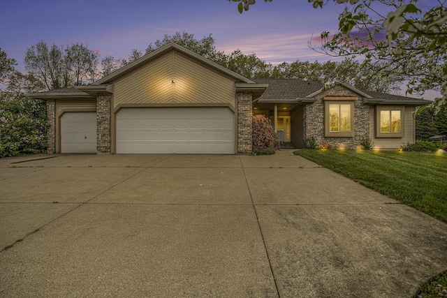 view of front facade with concrete driveway, an attached garage, brick siding, and a lawn