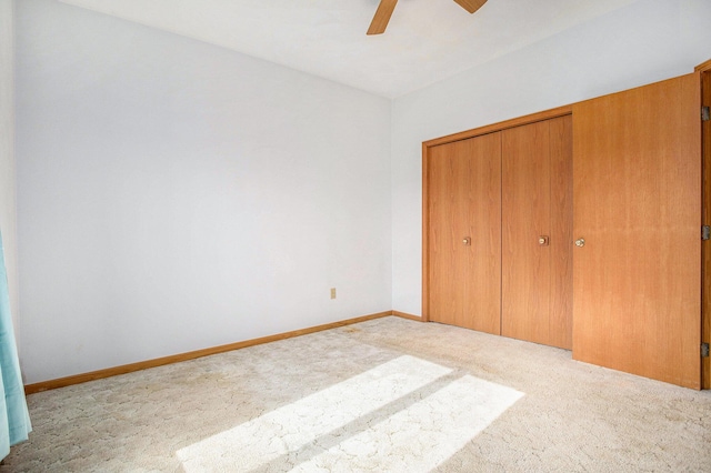 unfurnished bedroom featuring carpet floors, a closet, and a ceiling fan