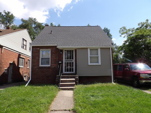 20136 Hull St, Detroit, MI 48203 - bungalow with a front yard, entry steps, roof with shingles, and brick siding