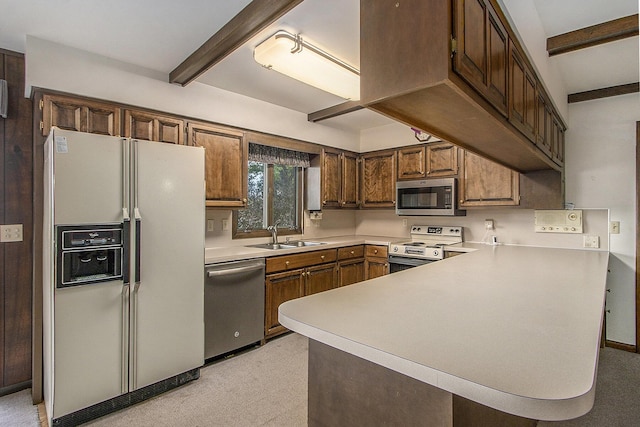 10706 Portage Rd, Portage, MI 49002 - kitchen with stainless steel appliances, a sink, beamed ceiling, a peninsula, and light countertops