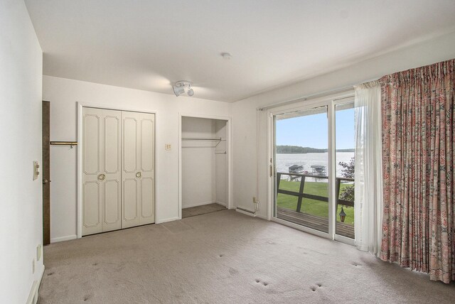 10706 Portage Rd, Portage, MI 49002 - unfurnished bedroom with a water view, access to outside, multiple closets, carpet, and baseboards