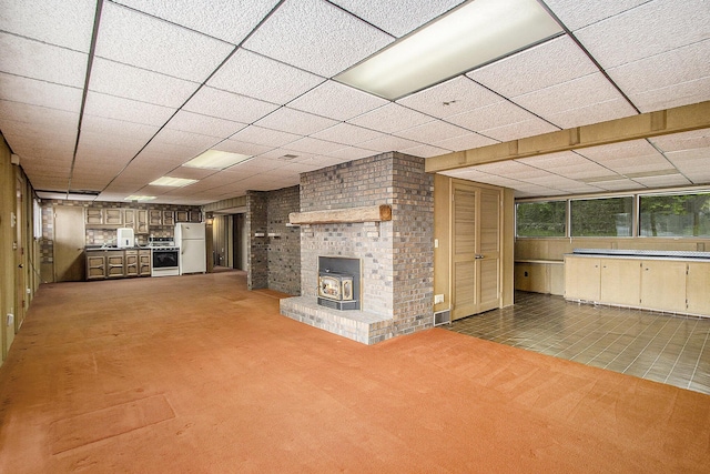 10706 Portage Rd, Portage, MI 49002 - unfurnished living room with a wood stove, carpet, and a drop ceiling