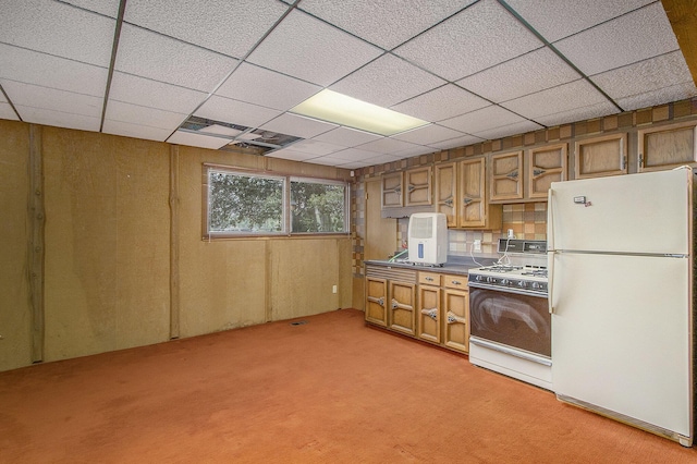 10706 Portage Rd, Portage, MI 49002 - kitchen featuring white appliances, light colored carpet, brown cabinetry, dark countertops, and a paneled ceiling