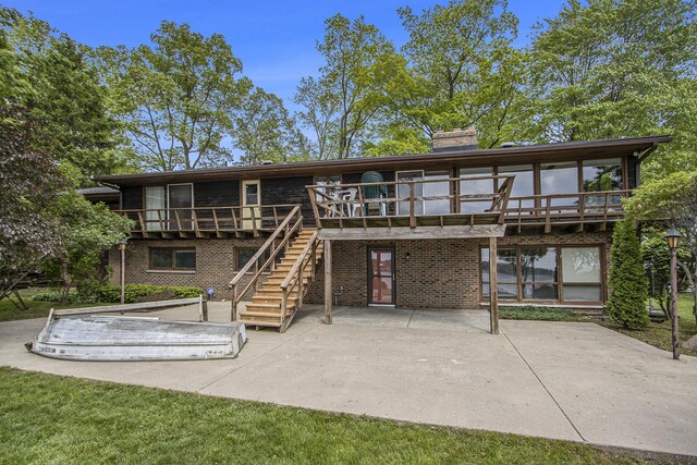 10706 Portage Rd, Portage, MI 49002 - rear view of property with a patio area, a wooden deck, a chimney, stairs, and brick siding