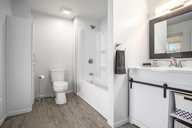 bathroom featuring wood finished floors, toilet, baseboards, and vanity