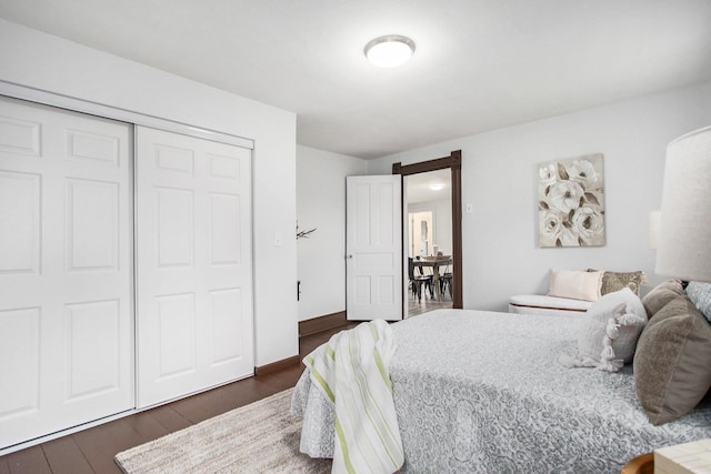 bedroom with dark wood-type flooring and a closet