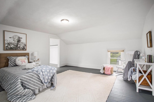bedroom with lofted ceiling, dark wood-style flooring, and baseboards