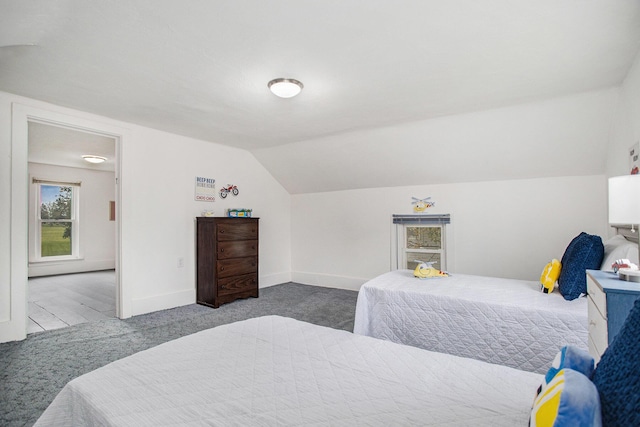 carpeted bedroom featuring lofted ceiling and baseboards