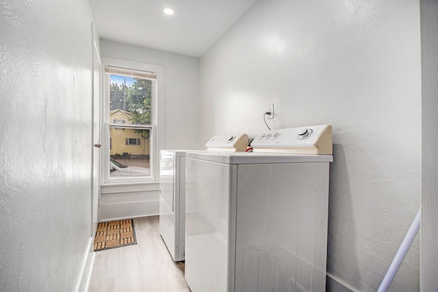 laundry room with washer and dryer, wood finished floors, and baseboards