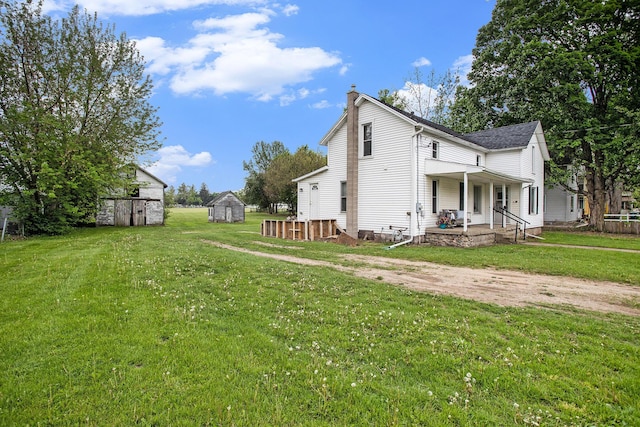 view of home's exterior with a storage shed, a chimney, an outbuilding, a porch, and a yard