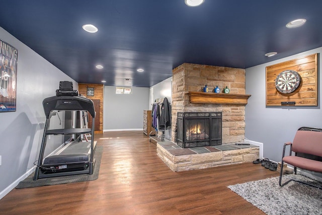 living room with baseboards, a stone fireplace, wood finished floors, and recessed lighting