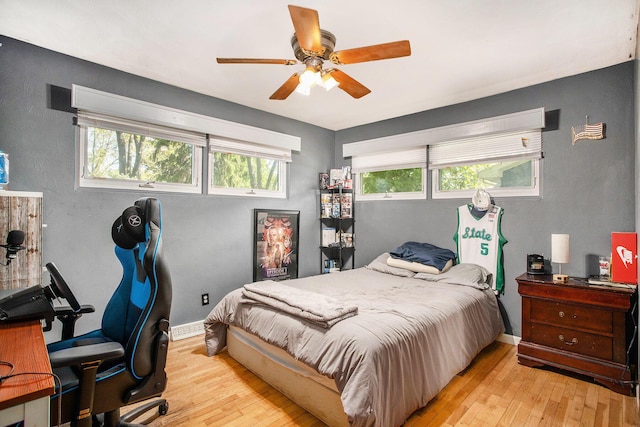 bedroom featuring light wood-type flooring, baseboards, and a ceiling fan