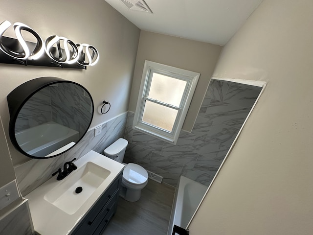 92 W Princeton Ave, Pontiac, MI 48340 - full bath featuring tile walls, toilet, vanity, wainscoting, and a tub to relax in