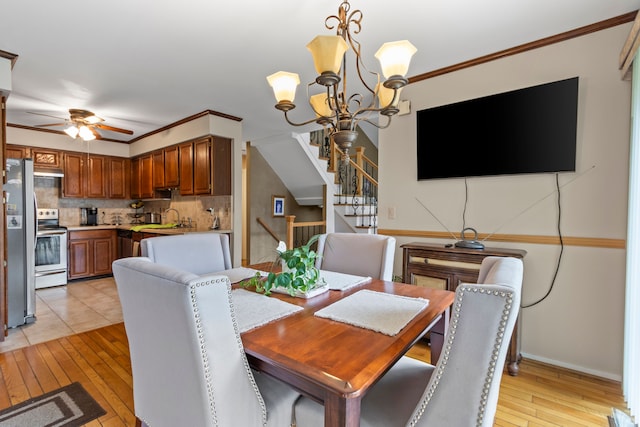 1696 S Hill Blvd, Bloomfield Hills, MI 48304 - dining space featuring light wood-style floors, a chandelier, stairs, ornamental molding, and ceiling fan