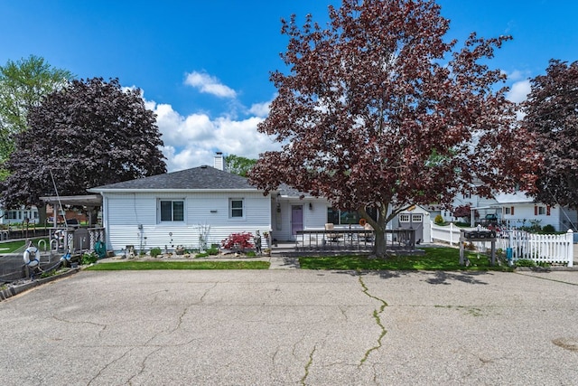 133 Loretta St, East China, MI 48054 - view of front of property with fence, a chimney, and a shingled roof
