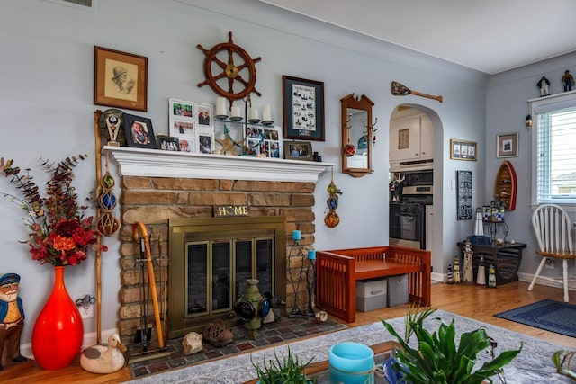 133 Loretta St, East China, MI 48054 - living room with wood finished floors, a fireplace, baseboards, and arched walkways