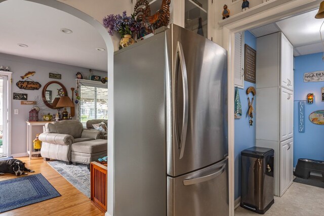 133 Loretta St, East China, MI 48054 - kitchen featuring freestanding refrigerator, white cabinets, arched walkways, and light wood finished floors
