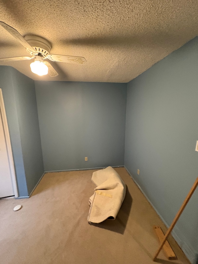 carpeted spare room featuring a ceiling fan and a textured ceiling