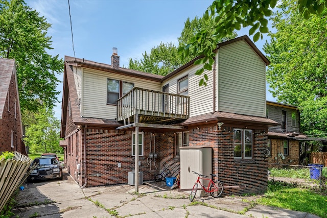 6110 Yorkshire Rd, Detroit, MI 48224 - rear view of house featuring a balcony, brick siding, fence, and a chimney