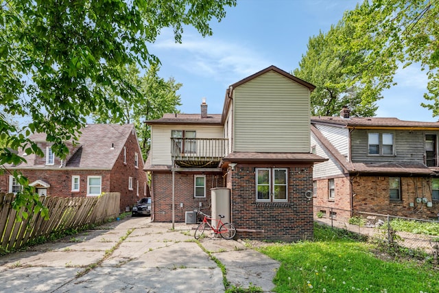 6110 Yorkshire Rd, Detroit, MI 48224 - back of house with a chimney, a fenced backyard, brick siding, and a patio