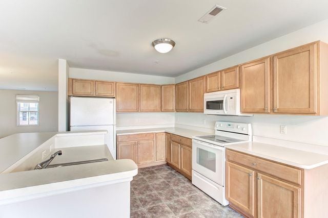 3986 Forester Blvd, Auburn Hills, MI 48326 - kitchen featuring white appliances, a sink, a center island, light countertops, and light brown cabinetry
