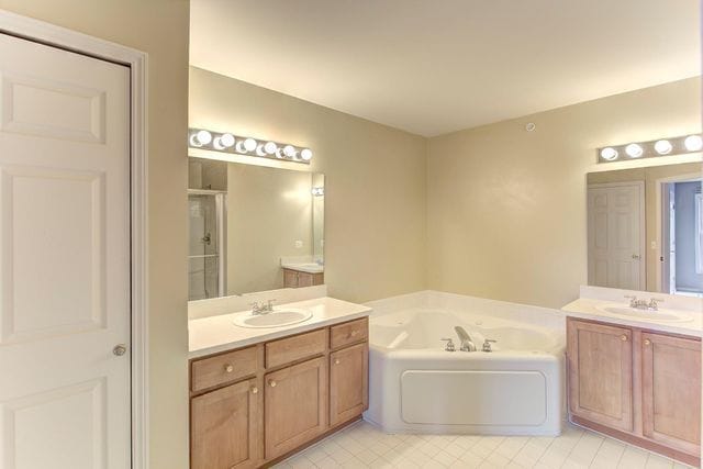 3986 Forester Blvd, Auburn Hills, MI 48326 - bathroom with a bath, two vanities, a shower stall, and tile patterned floors