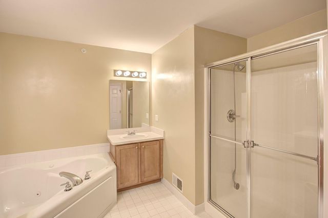 3986 Forester Blvd, Auburn Hills, MI 48326 - bathroom with a stall shower, a jetted tub, vanity, and tile patterned flooring