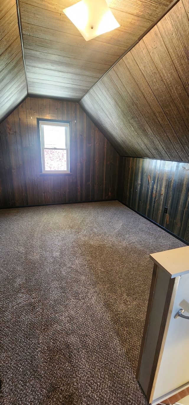 additional living space featuring wood walls, lofted ceiling, carpet flooring, and wood ceiling