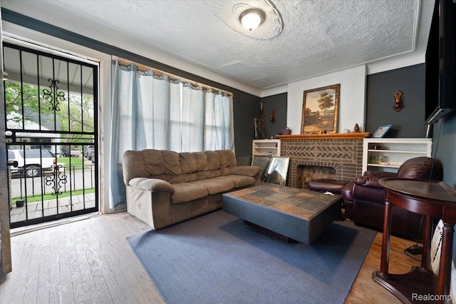 8214 Saint Marys St, Detroit, MI 48228 - living area with healthy amount of natural light, wood finished floors, a brick fireplace, and a textured ceiling