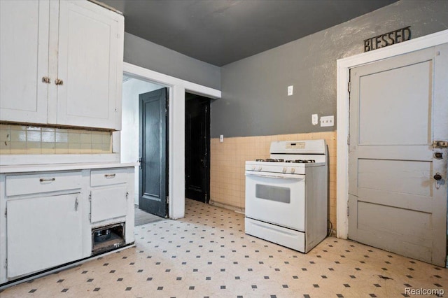8214 Saint Marys St, Detroit, MI 48228 - kitchen with white range with gas cooktop, tile walls, light floors, white cabinets, and light countertops