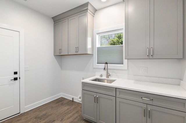 9693 Beverly Dr, Lakeland, MI 48143 - washroom featuring cabinet space, dark wood finished floors, and baseboards