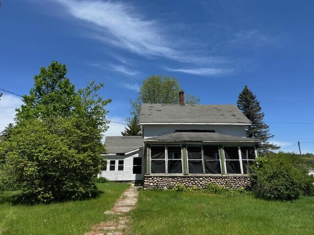 rear view of house with a sunroom and a shingled roof
