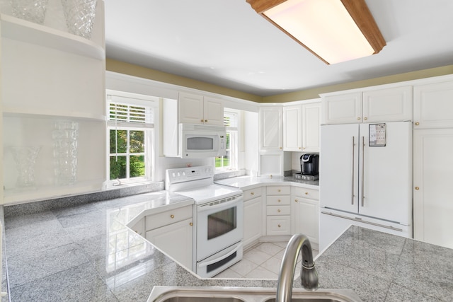 kitchen with white appliances, a sink, tile counters, and white cabinetry