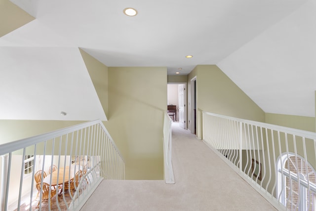 hallway with recessed lighting, plenty of natural light, vaulted ceiling, and carpet flooring