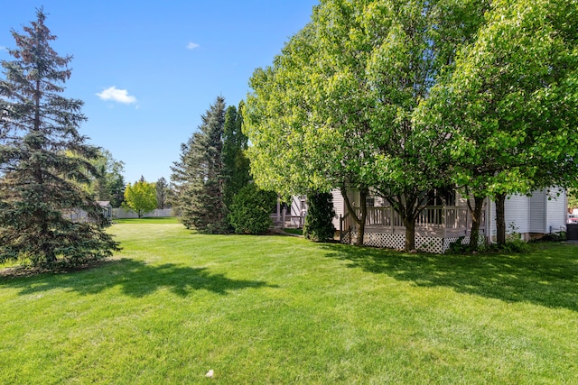 view of grassy yard with a deck