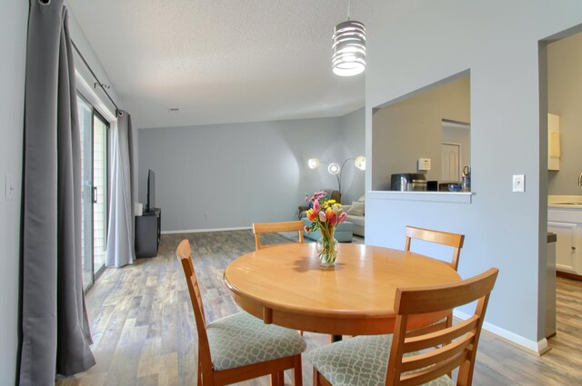 35844 Castlewood Ct, Westland, MI 48185 - dining area featuring light wood finished floors, a textured ceiling, and baseboards