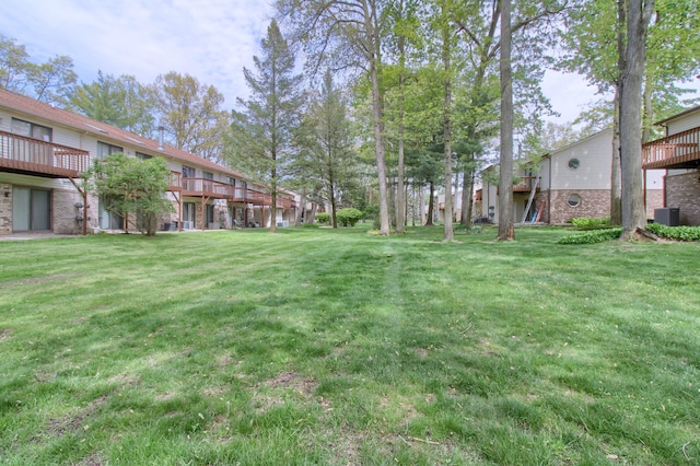35844 Castlewood Ct, Westland, MI 48185 - view of grassy yard featuring central AC unit and a deck
