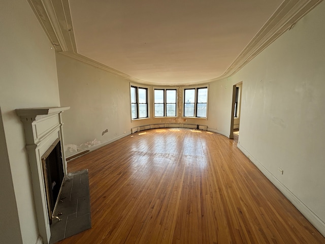 8162 E Jefferson Ave Unit 16B, Detroit, MI 48214 - unfurnished living room featuring crown molding, hardwood / wood-style floors, a fireplace with raised hearth, and baseboards