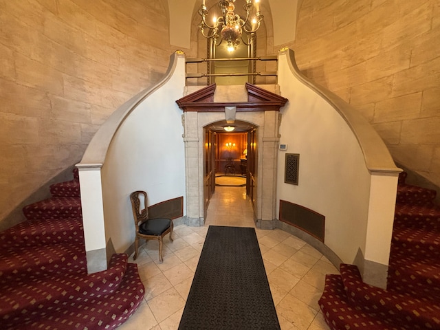 8162 E Jefferson Ave Unit 16B, Detroit, MI 48214 - stairway featuring arched walkways, a chandelier, tile patterned floors, and a towering ceiling